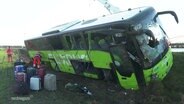 Ein verunglückter Bus liegt in Schräglage an einer Autobahn © Screenshot 