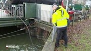 Arbeitende reinigen den Kanal vom Öl © Screenshot 