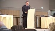 Oberbürgermeister Neubrandenburgs Silvio Witt steht bei einer Rede auf einer Bühne hinter einem Rednerpult. © Screenshot 