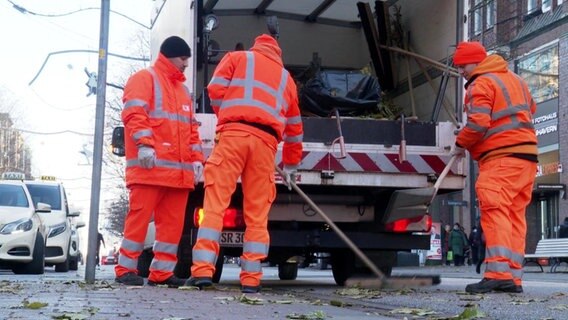 Drei Angestellte der städtischen Müllabfuhr an einem Müllwagen © Screenshot 