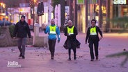 Eine Gruppe Wandernde mit gelben Warnwesten © Screenshot 