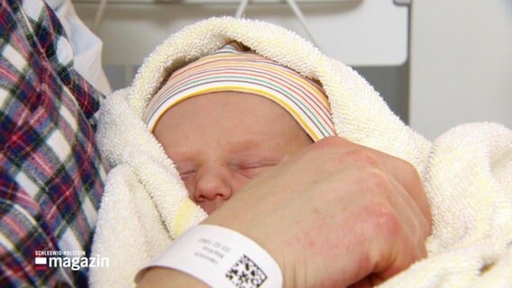 Ein Neugeborenes ist in eine Decke eingewickelt © Screenshot 
