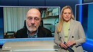 Juliane Möcklinghoff und Ulrich Wagner auf einem Bildschirm im Hintergrund. © Screenshot 