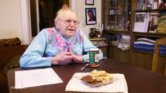 Eine ältere Frau mit Schläuchen in der Nase an einem Tisch sitzend. © Screenshot 