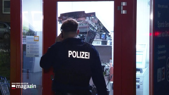 Ein Polizeibeamter vor einem beschädigten Geldautomaten. © Screenshot 
