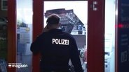 Ein Polizeibeamter vor einem beschädigten Geldautomaten. © Screenshot 