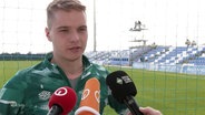 Mittelfeldspieler Niklas Schmidt von Werder Bremen gibt ein Interview am Spielfeldrand. © Screenshot 