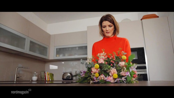 Moderatorin Frauke Rauner arrangiert einen Strauß Blumen in einer Küche. © Screenshot 