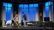 Zwei SchauspielerInnen performen auf einer Theaterbühne. © Screenshot 