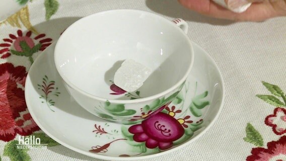 Eine Teetasse mit Kandiszucker. © Screenshot 