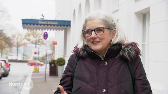 Helga Glaesner steht vor dem Hotel Atlantic in Hamburg. © Screenshot 