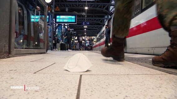Eine Maske liegt an einem Bahnsteig © Screenshot 