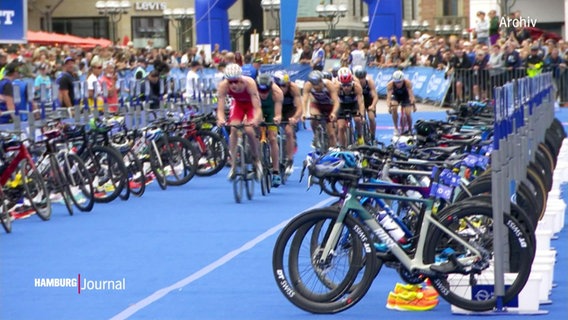 Mehrere Radfahrer fahren im Zuge der Triathlon-WM eine Straße entlang. © Screenshot 