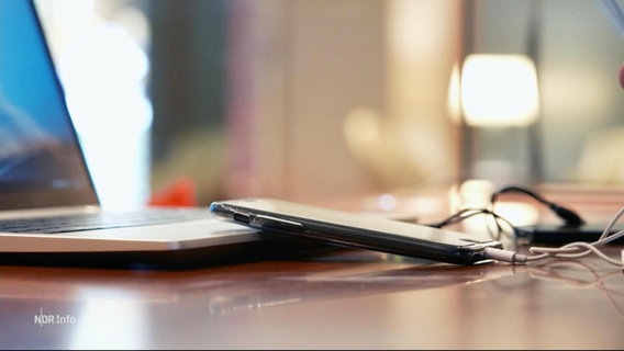 Handy und Laptop auf einer Tischplatte © Screenshot 
