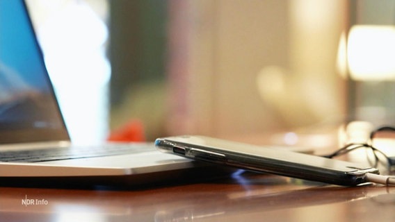 Ein Smartphone liegt angelehnt an einem Laptop © Screenshot 