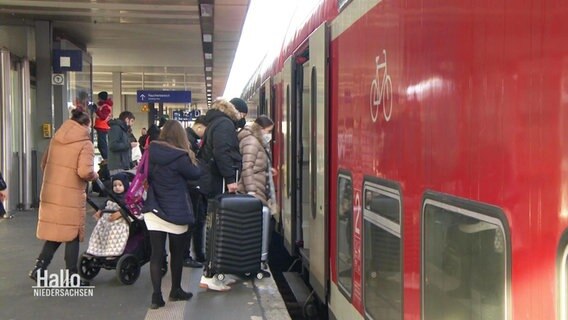 Eine Gruppe von Menschen steigt in eine Bahn ein © Screenshot 