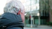 Jens-Uwe Claaßen trägt ein Cochlea Implantat hinter seinem Ohr © Screenshot 