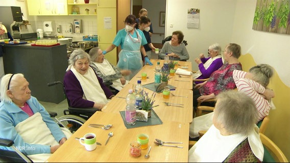 Eine Pflegekraft singt mit mehreren Senioren in einem Heim. © Screenshot 