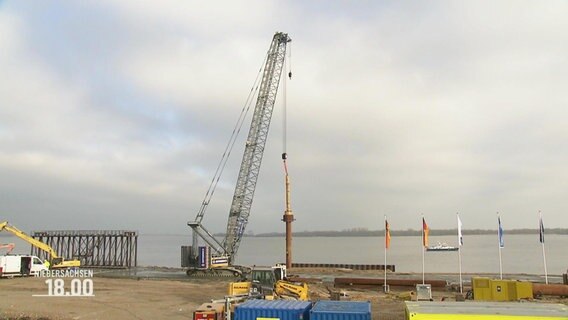 Ein Kran setzt den ersten Rammschlag fürein LNG-Terminal in Stade. © Screenshot 