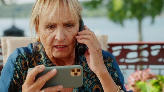 Mechthild entdecht etwas auf ihrem Telefon. © Screenshot 