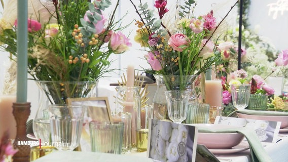 Blumendekoration steht auf einem Tisch. © Screenshot 