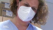 Eine Mitarbeiterin in einem Krankenhaus trägt eine FFP2-Maske. © Screenshot 