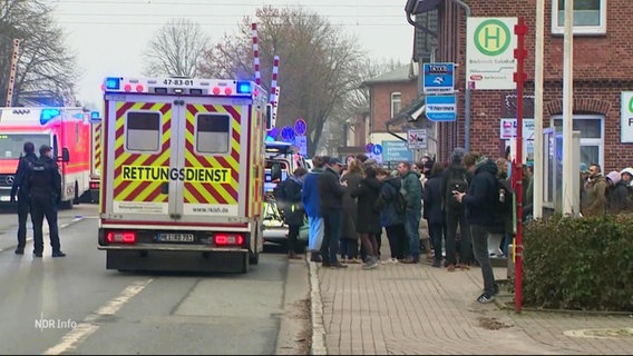 Menschengruppe vor einem Krankenwagen. © Screenshot 