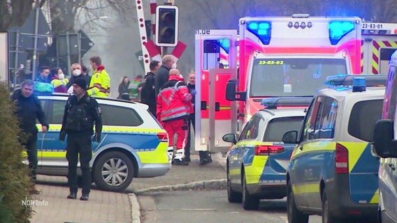 Auf einer Straße stehen mehrere Einsatzkräfte von Polizei und Rettungsdienst sowie deren Einsatzfahrzeuge. © Screenshot 