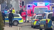 Auf einer Straße stehen mehrere Einsatzkräfte von Polizei und Rettungsdienst sowie deren Einsatzfahrzeuge. © Screenshot 