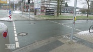 Blick auf eine leicht nasse Fahrbahn an einer Straßenkreuzung mit Ampel-Übergang in Hannover. © Screenshot 