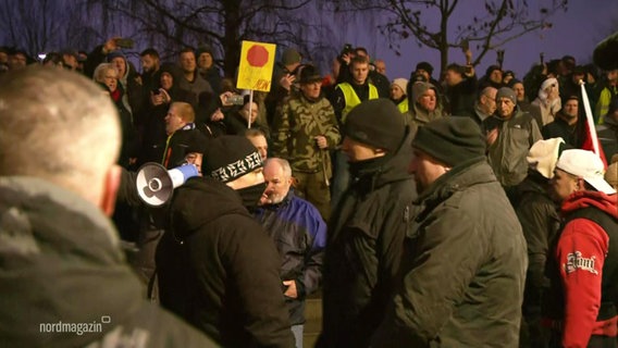 Protestierende in Grevesmühlen, einer von ihnen trägt eine Mütze mit einem Muster, das Rechtsradikalen zugeordnet werden kann. © Screenshot 