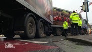 Nach einem Verkehrsunfall sichern Verkehrspolizisten die Unfallstelle ab an der ein zweigliedriger Lkw nach rechts abgebogen ist. © Screenshot 