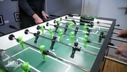 Ein Tisch-Fußball mit grünen und schwarzen Figuren. © Screenshot 