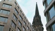 Zwischen Neubauten ist der Turm der Hamburger Mahnmals St. Nikolai zu sehen. © Screenshot 