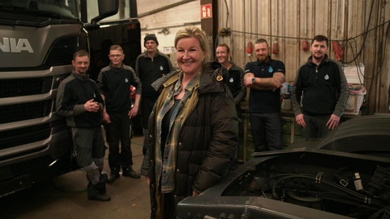 Das Team der Auto-Reinigungsfirma Dabelstein steht für ein Foto zusammen in der Werkstatt. © Screenshot 