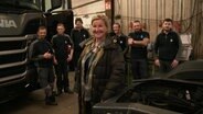 Das Team der Auto-Reinigungsfirma Dabelstein steht für ein Foto zusammen in der Werkstatt. © Screenshot 