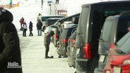 Viele parkende Autos in einem Skigebiet. © Screenshot 