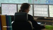Eine Frau sitzt an einem Schreibtisch mit mehreren Bildschirmen in der Leitstelle der Hochbahn. © Screenshot 