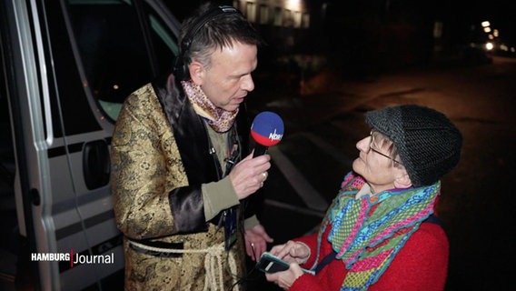 Moderator Ulf Ansorge interviewt eine Zuschauerin vor einem Camper. © Screenshot 