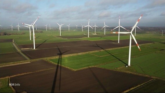 Blick aus hoher Höhe: Über einen weites Landstück stehen mehrere Windkrafträder auf Feldern. © Screenshot 