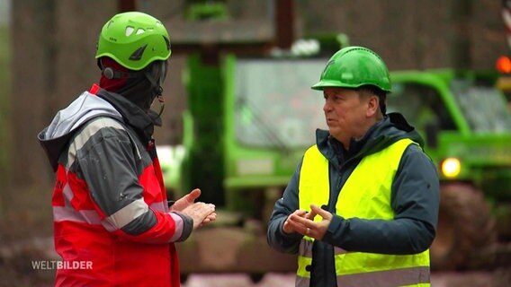 Unterhaltung zwischen zwei Bauarbeitern in Arbeitskleidung an der deutsch-französischen Grenze. © Screenshot 