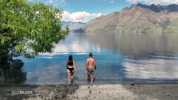 Weitaufnahme eines Paars, die in einem Neuseeländer See schwimmen gehen. © Screenshot 