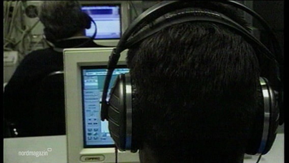 Eine Person mit Kopfhörern sitzt vor einem Computer © Screenshot 