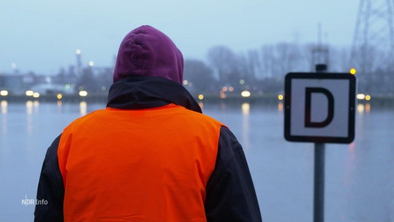Ein Mann wird von hinten gefilmt und schaut auf den Nord-Ostsee-Kanal. © Screenshot 