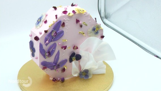 Ein mit Blüten dekoriertes Stück Torte. © Screenshot 