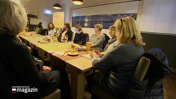 Mehrere Frauen sitzen um einen Tisch und sprechen miteinander. © Screenshot 