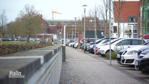 Blick in eine frisch gepflasterte Straße in einem Wohngebiet mit mehreren geparkten Autos. © Screenshot 