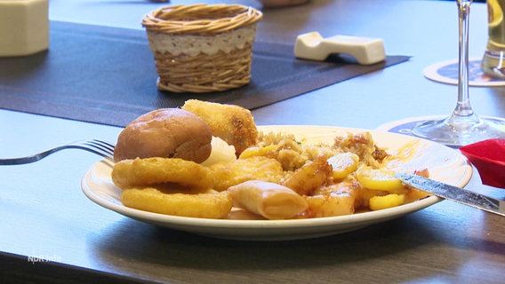 Auf einem Tisch in einem Restaurant steht ein Teller mit mehreren asiatischen Speisen. © Screenshot 