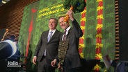 Finanzminister Lindner auf einer Bühne mit einem Strauß Grünkohl in der Hand. © Screenshot 