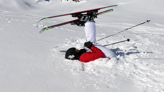 Ein Skifahrer liegt im Schnee. © NDR 